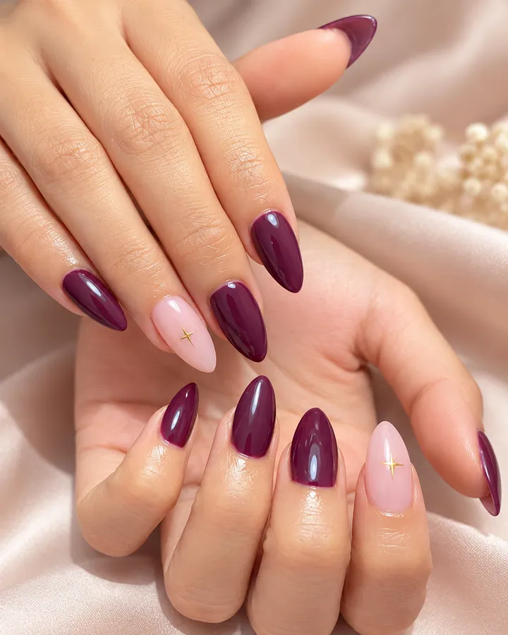Nail art plum dan nude dengan aksen bintang emas